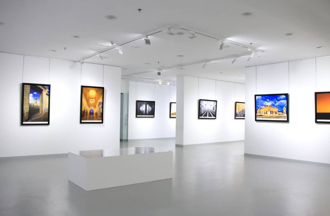 art-lovers-guide-cape-town A bright white room featuring multiple framed photographs elegantly displayed on the walls.