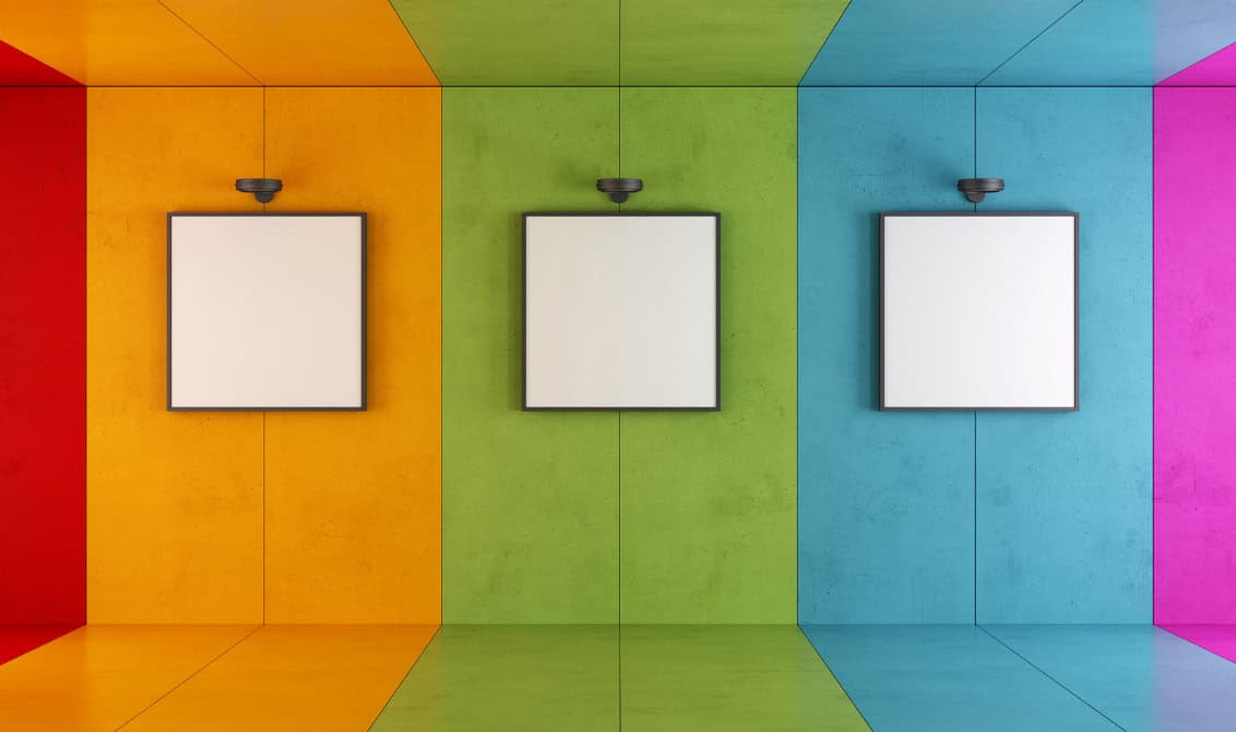 cape-winelands-art-galleries Three empty frames mounted on a colorful wall in a room at Century City Hotel, showcasing a vibrant interior design.