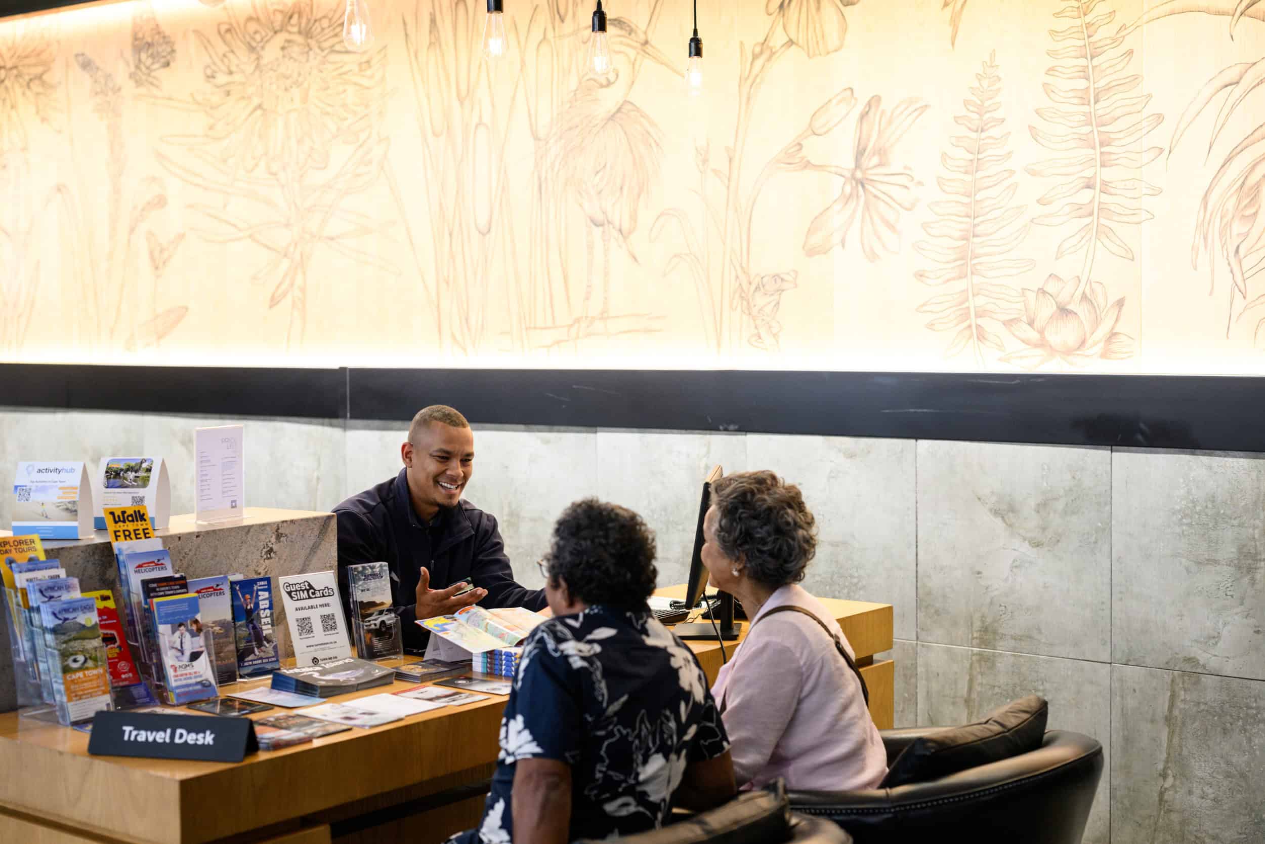 Century City Hotels A smiling couple meeting with a Century City Hotel’s consultant at their travel desk