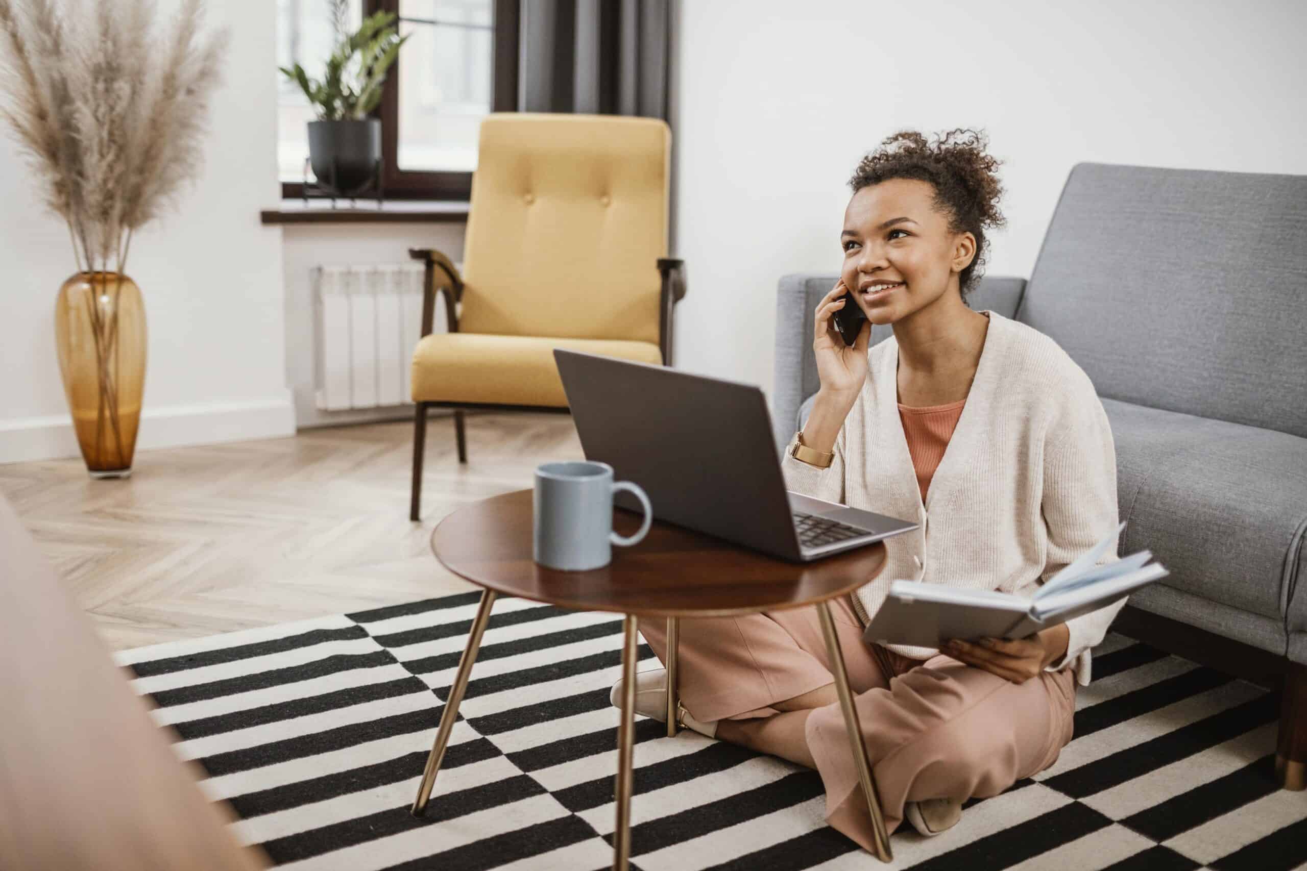 young-woman-working-from-modern-place (1) A female entrepreneur sitting on a modern floor at a small table, working as one of the digital nomads Cape Town